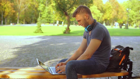 Caucasian Guy Works on Computer at the Open Air alt