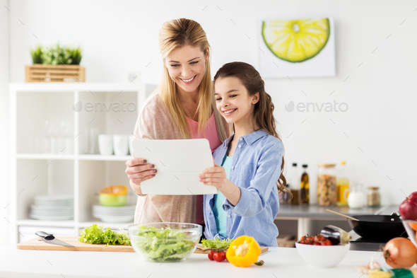 family cooking dinner using tablet pc at kitchen