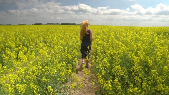 Young Blonde Woman Posing in Beautiful Rapeseed Field