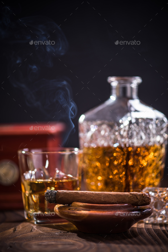 Cuban cigar smoking in wooden ashtray