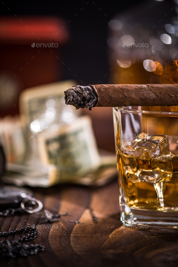 Cuban cigar and cognac over ice cubes