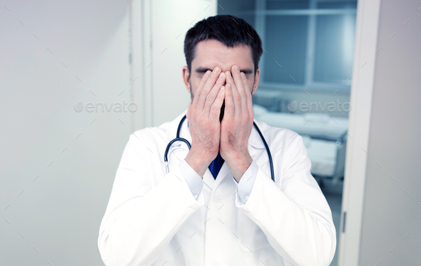 sad or crying male doctor at hospital ward