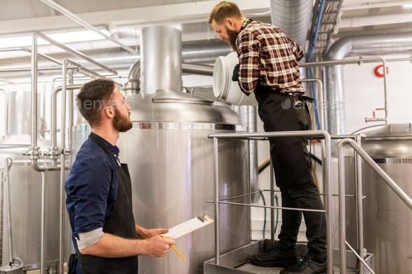 men working at craft brewery or beer plant - Stock Photo - Images