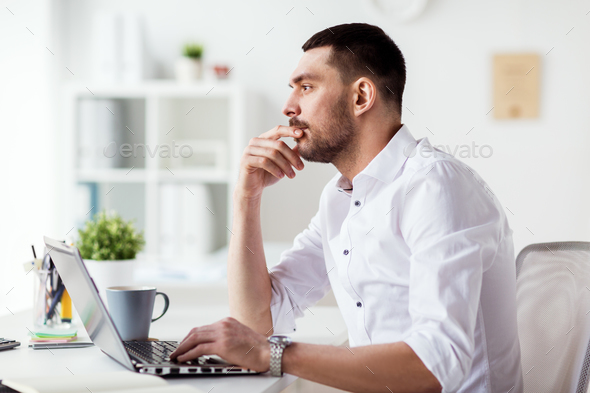 businessman with laptop thinking at office - Stock Photo - Images