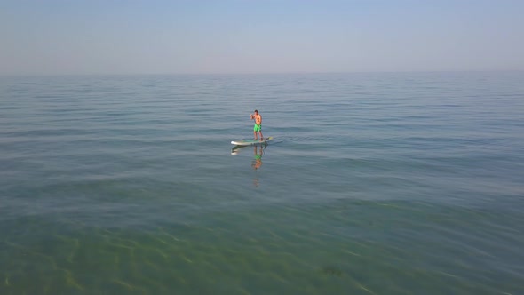 Aerial Drone View of a Man Paddling on a Sup Stand Board