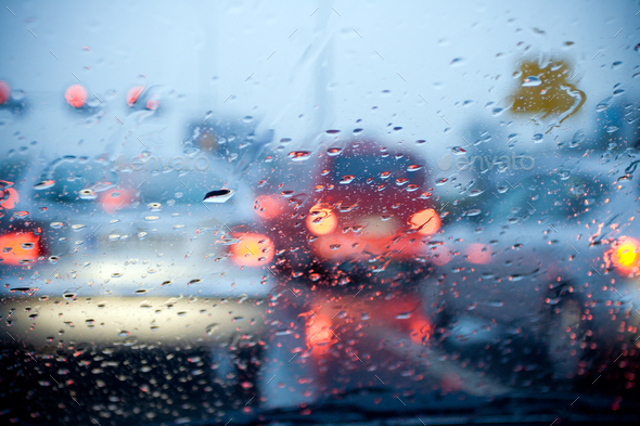Car driving in a rain storm with blurred red lights - Stock Photo - Images