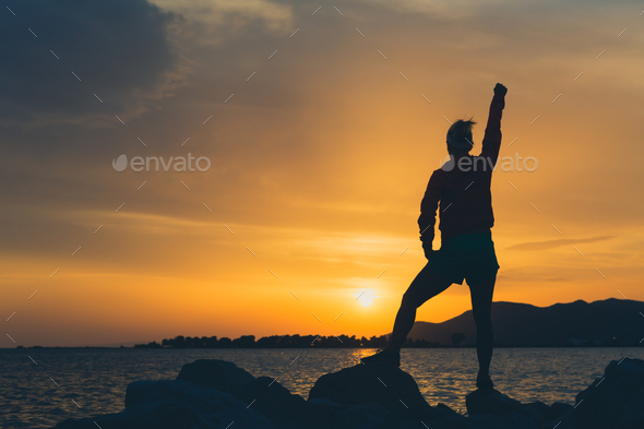Woman hiker with arms outstretched enjoy beach and sea
