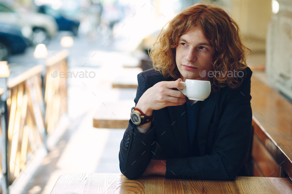 Portrait fashionable reddish man drinking coffee