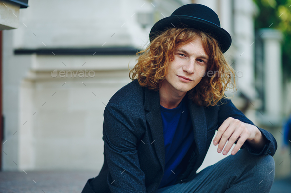 Red haired hipster man sitting on stairs posing - Stock Photo - Images