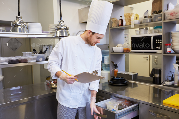 chef with clipboard doing inventory at kitchen