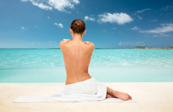 beautiful woman in towel with bare back on beach