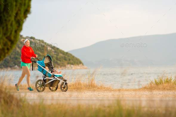 Mother running with stroller, enjoying motherhood at sunset land