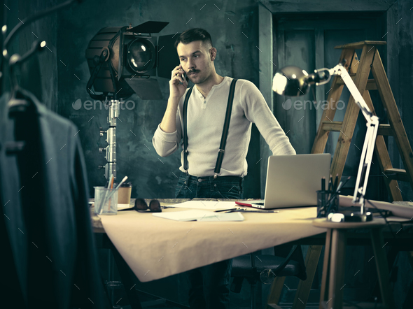 Portrait of a bearded businessman who is working with his notebook at loft studio.