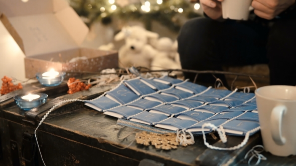 Young Couple Spending Evening at Home with Advent Calendar Opening Christmas Presents alt