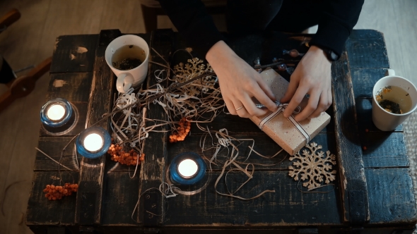Female Sitting at the Table with Decorating Staff and Making the Present alt