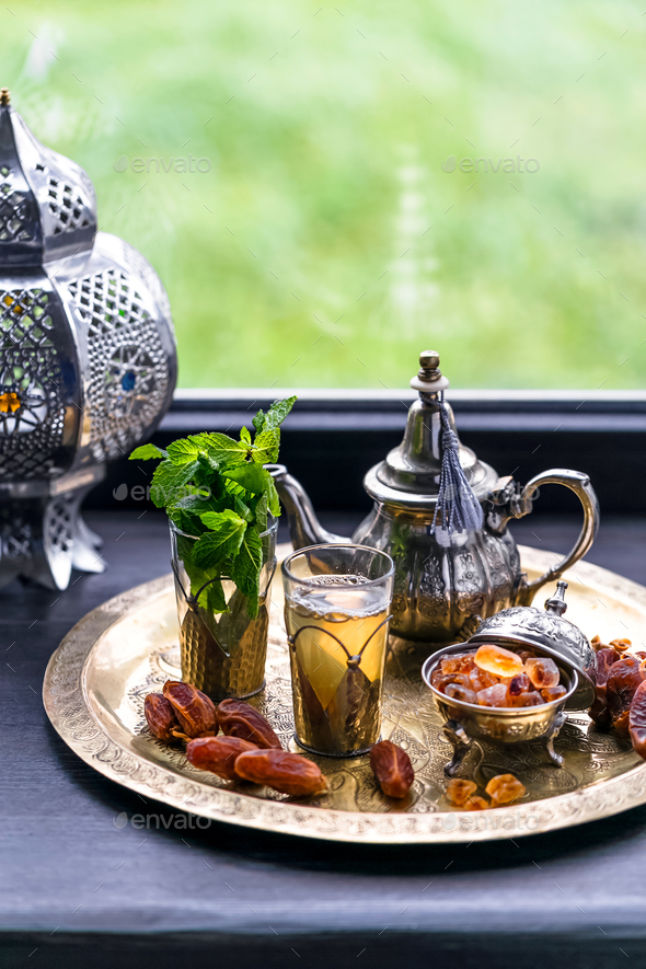 Moroccan tea with mint and sugar in a glasses on a copper plate with