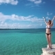 A Girl Stands on a Rock Against the Azure Water of the Caribbean Sea - VideoHive Item for Sale