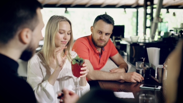 Company of Friends Sitting at a Bar Counter in Summer Day. Beautiful Girl Taking From Table  alt