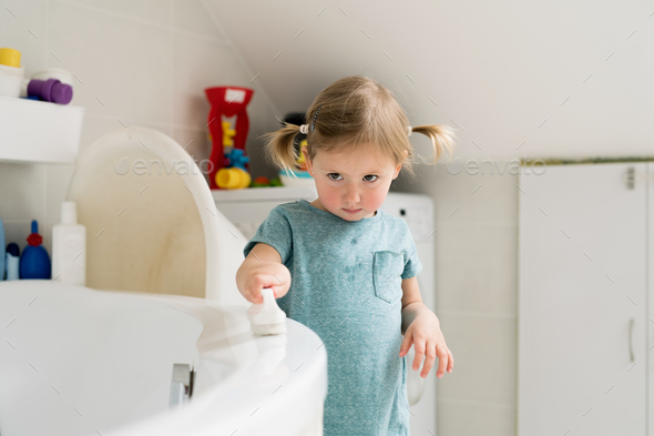 Little girl in bathroom cleaning bathtub with a brush. Stock Photo by ...