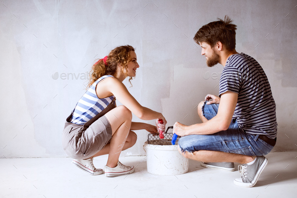 Young couple in love painting walls in their new home. - Stock Photo - Images