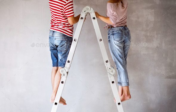 Unrecognizable couple painting walls in their house. - Stock Photo - Images