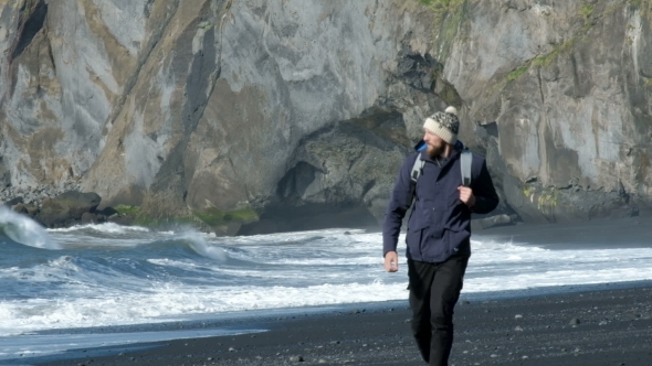 VideoHive Man with a Backpack Walking Along the Shore of Black Sand Beach in Iceland 20755004 VideoHive Man with a Backpack Walking Along the Shore of Black Sand Beach in Iceland 20755004