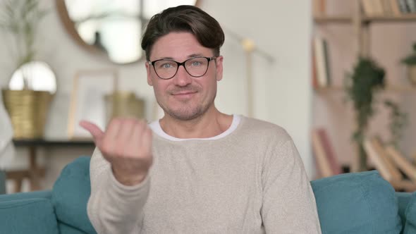 Middle Aged Man Pointing and Inviting at Home  alt