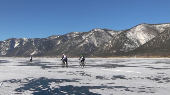 Men Riding a Bicycle on the Surface of Frozen Lake