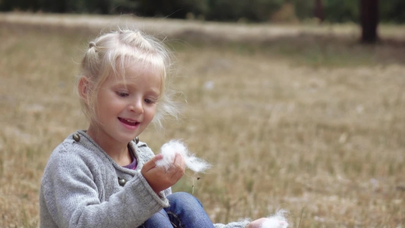 Girl Child Blowing Fluff of Bulrush