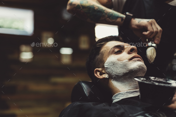 Barber shaving client - Stock Photo - Images