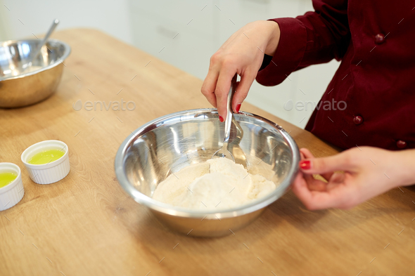 chef with flour in bowl making batter or dough