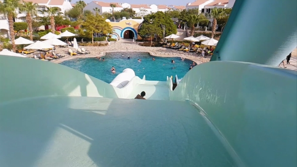 Child Is Riding a Water Slide in Water Park