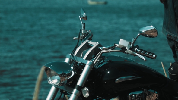 Black Chopper Bike Standing on Blue Sea Shore