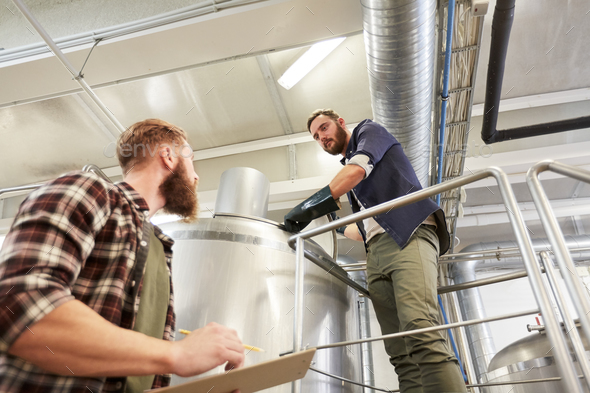 men with clipboard at brewery or beer plant kettle - Stock Photo - Images