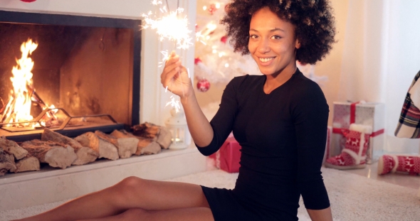 Fun Young Woman Burning a Sparkler for Christmas