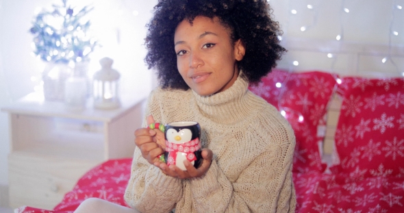 Smiling Woman Enjoying a Cup of Christmas Coffee