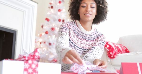 Young Woman Opening Her Christmas Gifts