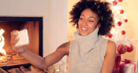 Elegant Young Woman Taking a Christmas Selfie