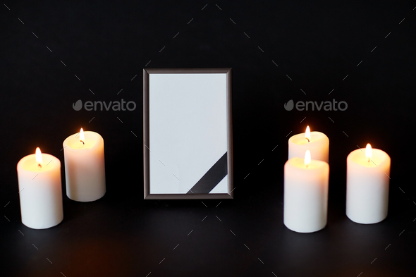 black ribbon on photo frame and candles at funeral