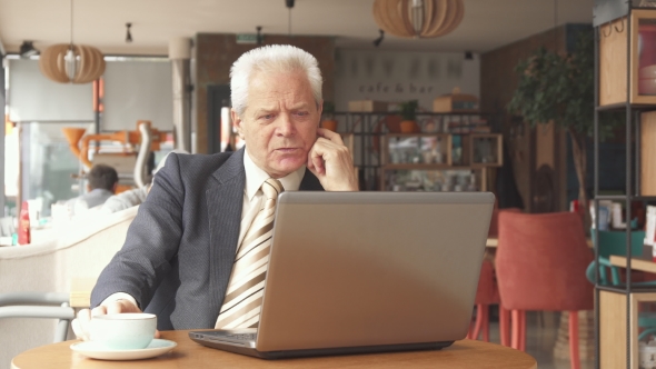 Senior Businessman Looking at the Laptop Screen alt