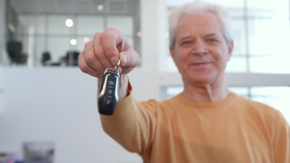 Senior Man Shakes Car Key in His Hand