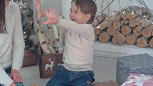 Young Mother and Excited Boy Counting Christmas Presents on His Fingers alt