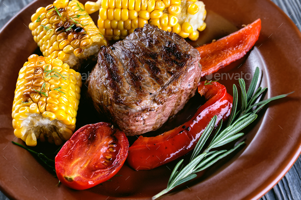 Piece of baked meat with vegetables and marinated on plate - Stock Photo - Images