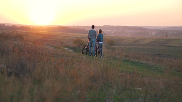 A Happy Couple with Bikes at Sunset