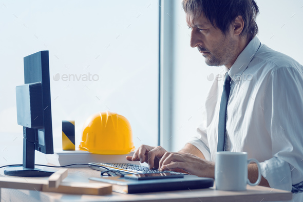 Construction engineer working on desktop computer using CAD soft