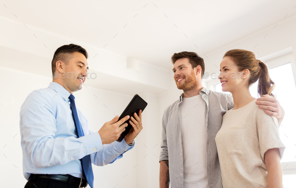 couple and realtor with tablet pc at new home