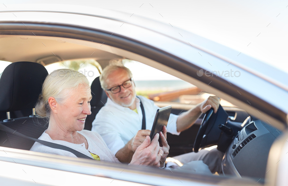 happy senior couple with tablet pc driving in car