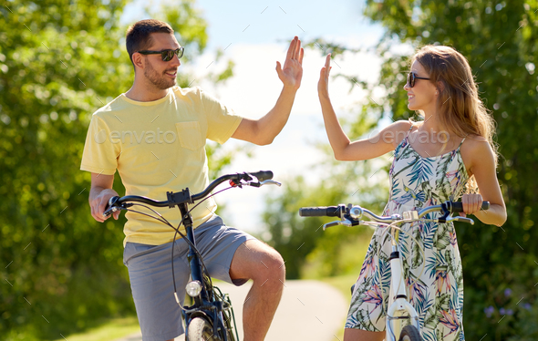 happy couple with bicycles making high five