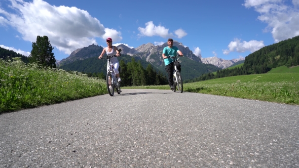 Couple Woman and Man on Electric Eco Bike Cycling Italy Dolomites Alps