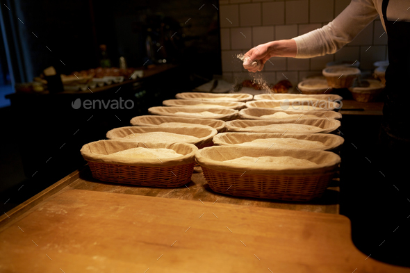 baker with baskets for dough rising at bakery - Stock Photo - Images